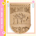 A wooden sign with the text "HOME SWEET HOME" and an illustration of a watering can and flowers.