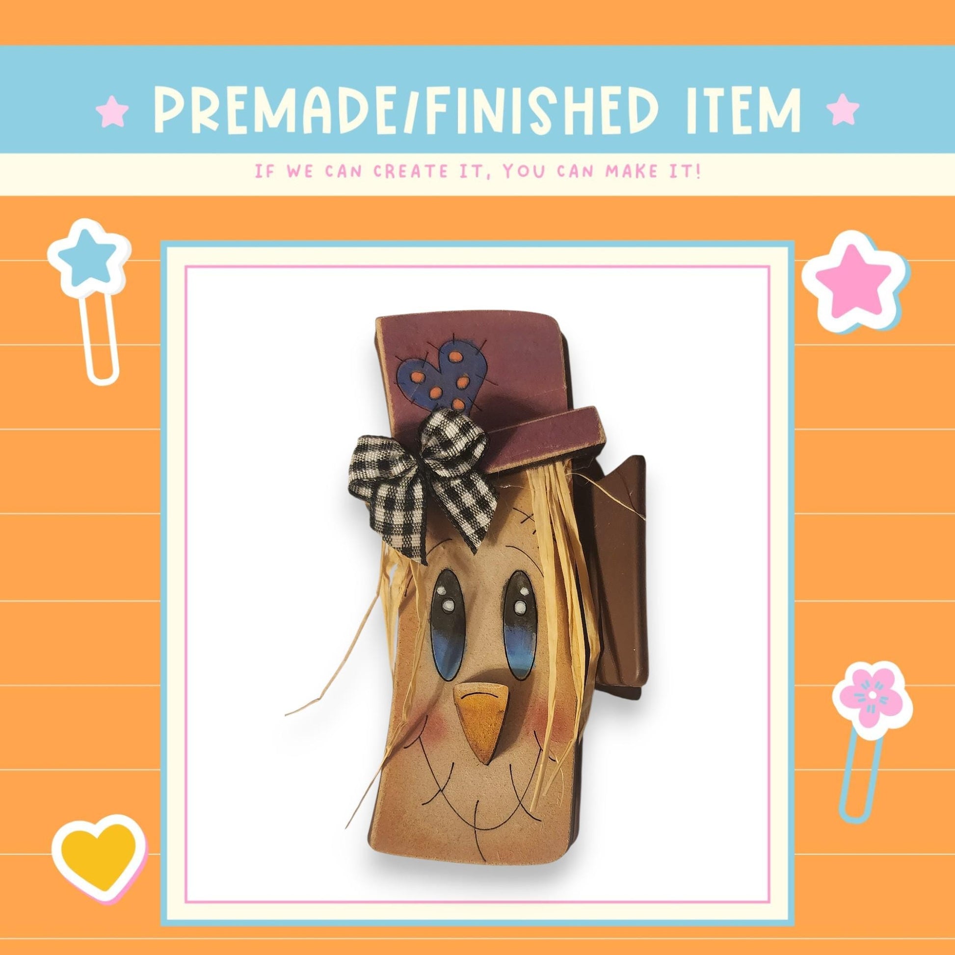 a homemade scarecrow-like item with a face and hat, surrounded by decorative elements such as stars and hearts.