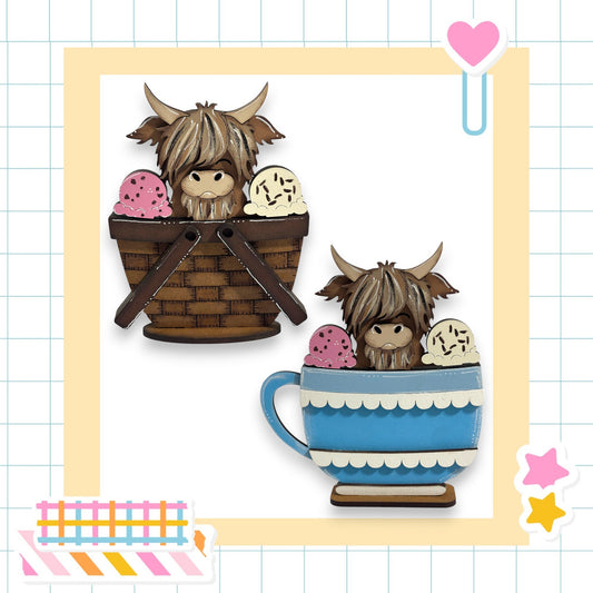 two wooden cutouts of animals, specifically cows, sitting in baskets and cups, respectively. The baskets are brown and appear to be made of wood, while the cups are blue and have a scalloped edge. The background of the image is a grid pattern, and there are various colorful stickers and a heart-shaped object present in the scene.