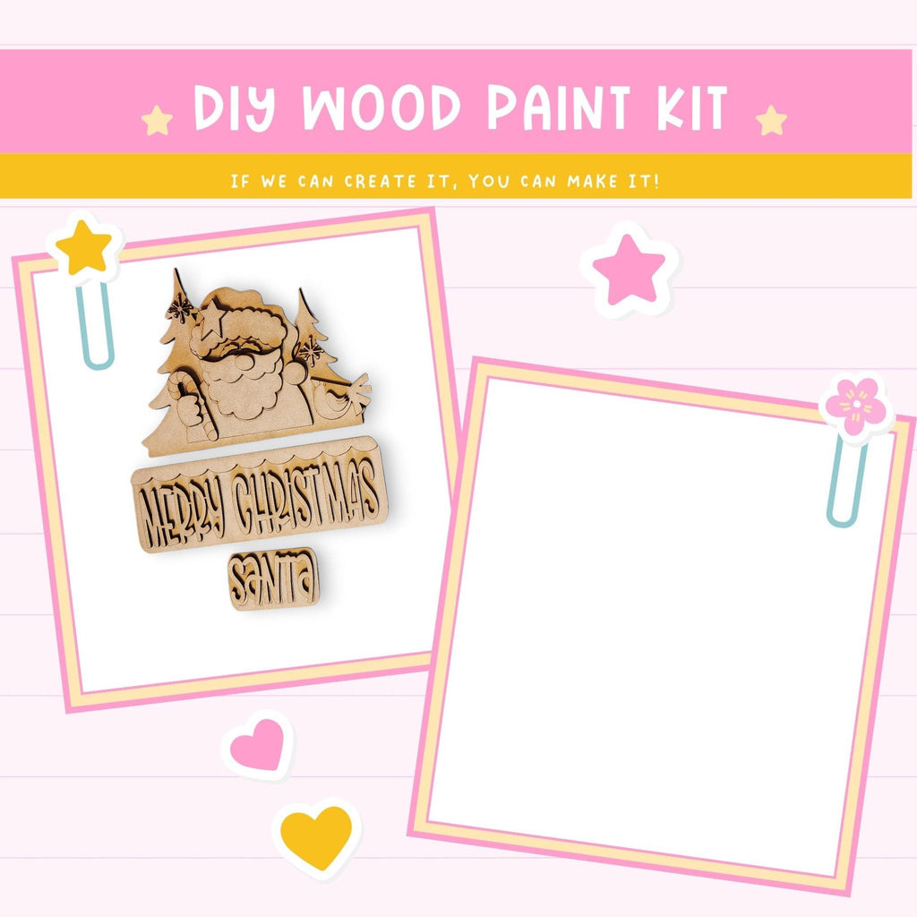 The image is a DIY wood paint kit with a pink background and a message encouraging creativity. It features a wooden Santa Claus figure and a blank white frame, along with decorative elements such as hearts and stars.