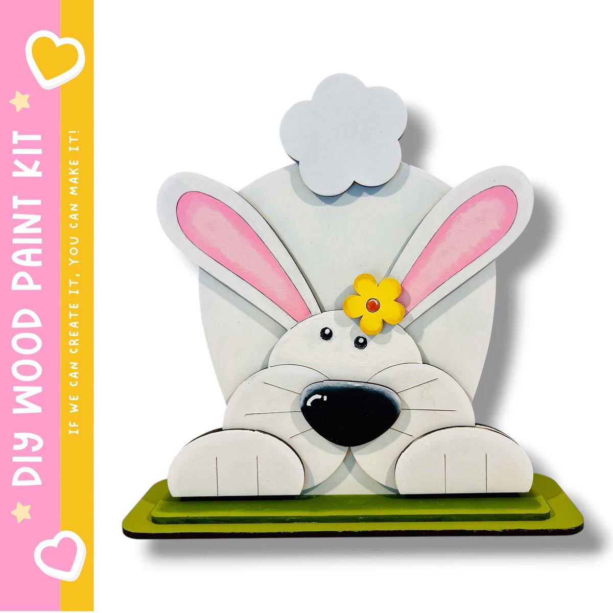 A wooden bunny sculpture with pink ears and a yellow flower on its head, sitting on a green base.