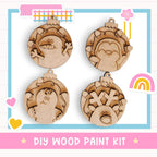 a DIY wood paint kit with four wooden ornaments, each with a unique design, displayed on a white background.
