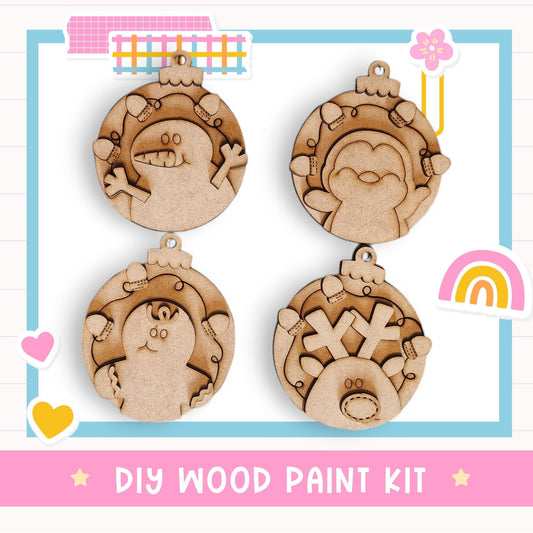 a DIY wood paint kit with four wooden ornaments, each with a unique design, displayed on a white background.