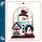 A snowman figure with a clock and a sign that says "let it snow" is displayed in a decorative wooden frame.
