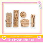 a DIY wood paint kit with various wooden shapes and designs, including a wooden fence, a wooden apple, and a wooden bird.