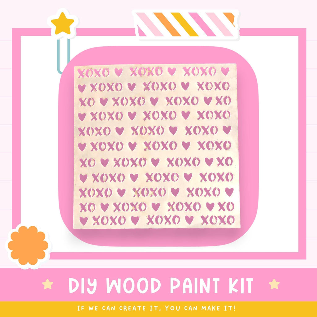 The image is a promotional poster for a DIY wood paint kit. It features a pink background with a repeating pattern of the word "XOXO" in various sizes and colors. The text "DIY WOOD PAINT KIT" is prominently displayed, along with the phrase "IF WE CAN CREATE IT, YOU CAN MAKE IT!" at the bottom of the image.