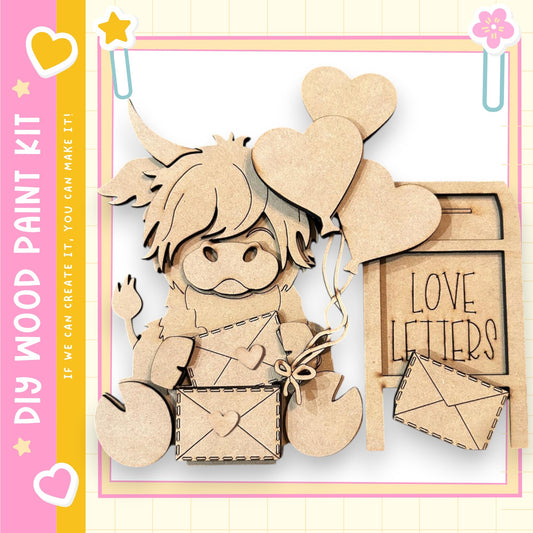 The image is a wooden paint kit featuring a wooden cutout of a person holding a bunch of wooden hearts and a wooden sign that says "Love Letters".