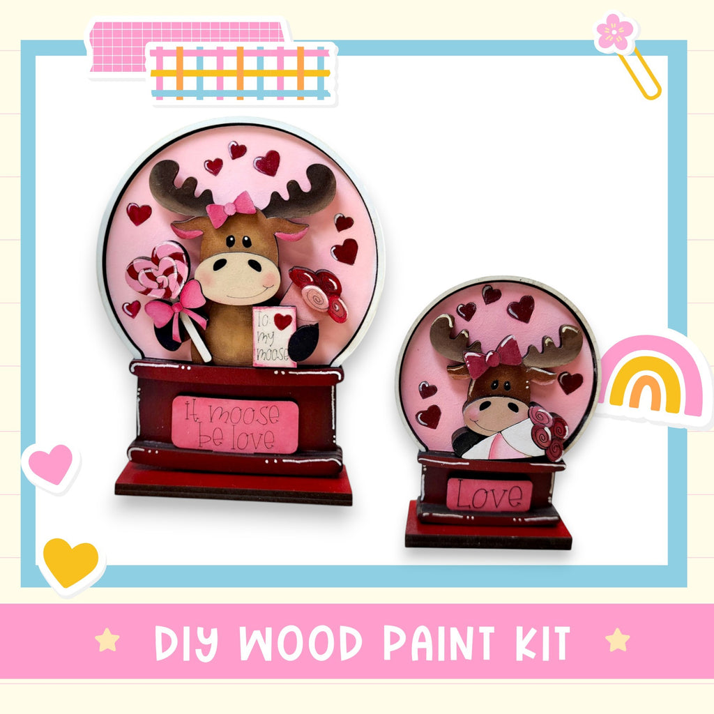 two wooden paint kits, each depicting a moose with a heart-shaped design. The kits are labeled as "DIY WOOD PAINT KIT" and "Love".