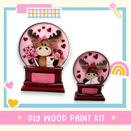 two wooden paint kits, each depicting a moose with a heart-shaped design. The kits are labeled as "DIY WOOD PAINT KIT" and "Love".