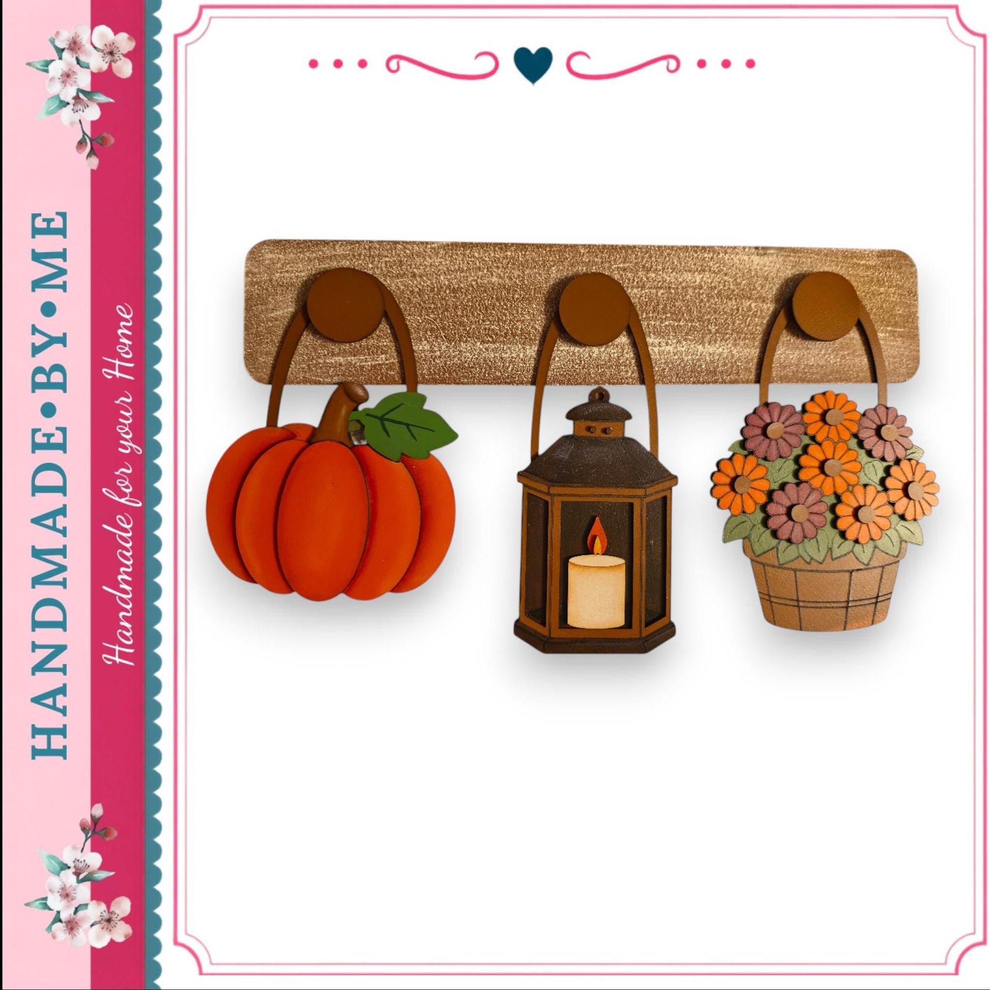 a wooden shelf with three decorative items hanging on it: a red pumpkin, a lantern, and a basket of flowers.