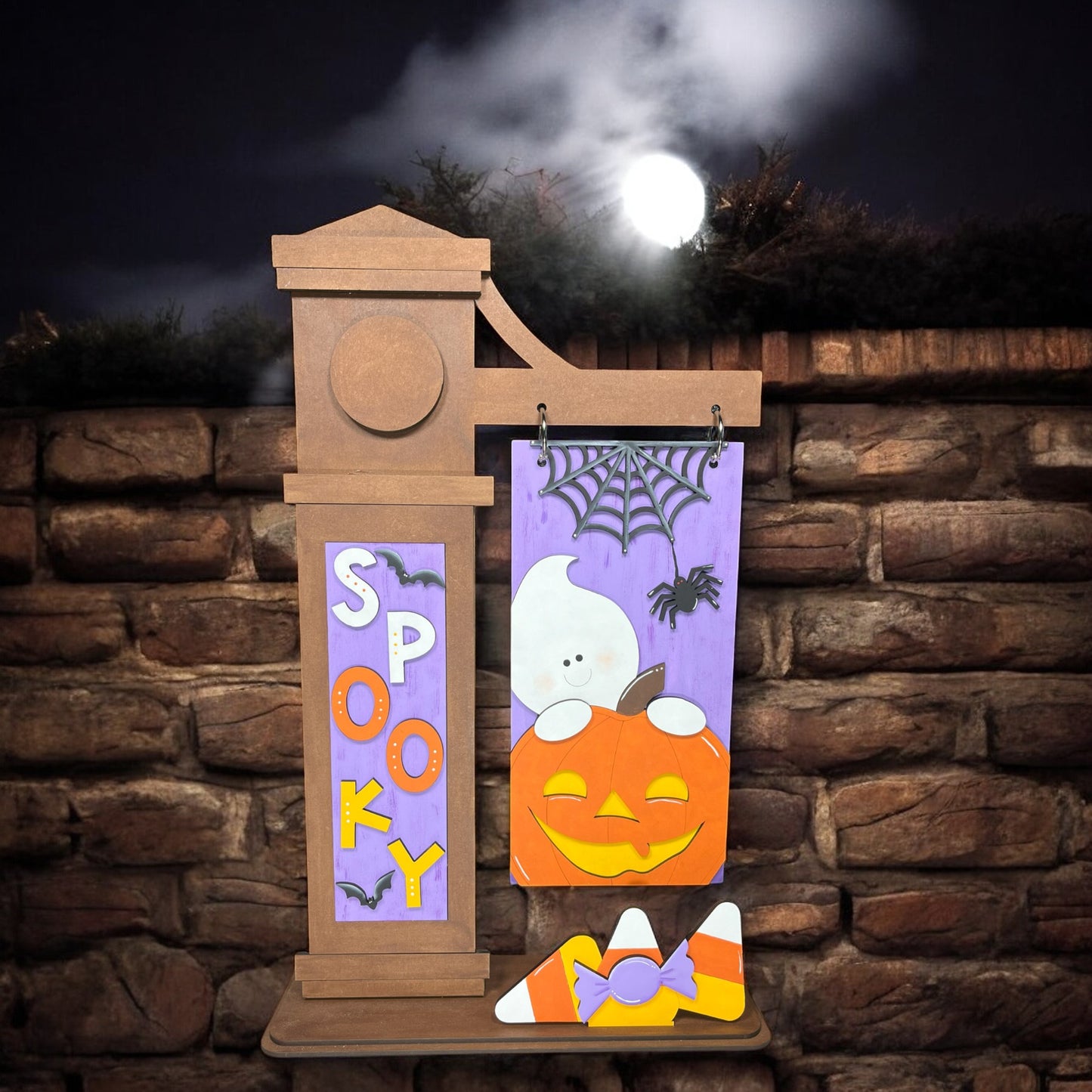 a wooden sign with a ghost and pumpkin on it