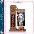A Halloween-themed DIY kit featuring a skeleton decoration, a carved pumpkin, and a clock.