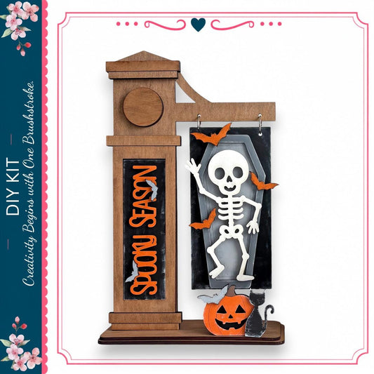 A Halloween-themed DIY kit featuring a skeleton decoration, a carved pumpkin, and a clock.