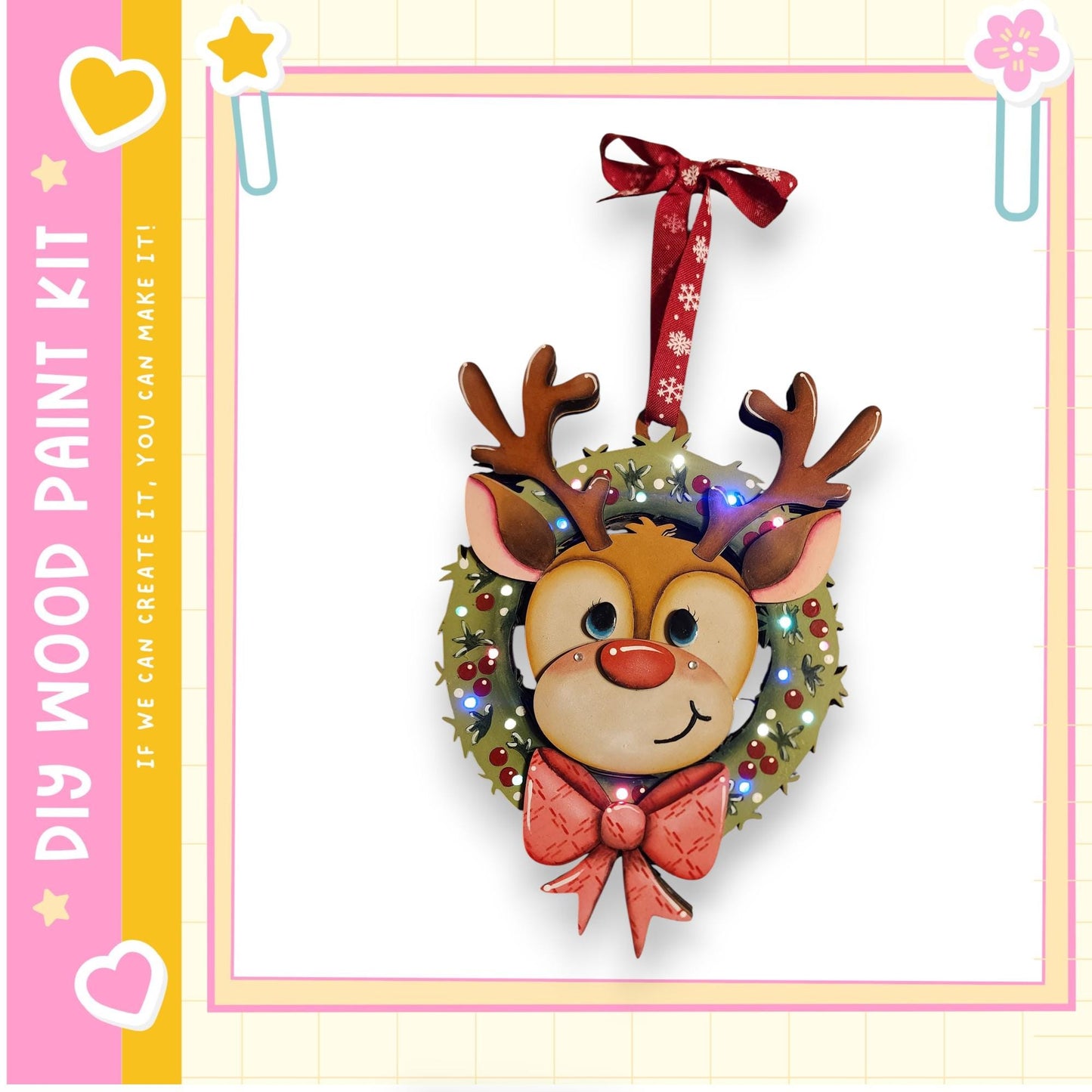 A festive wreath with a smiling reindeer face and a red ribbon, hanging on a wall.