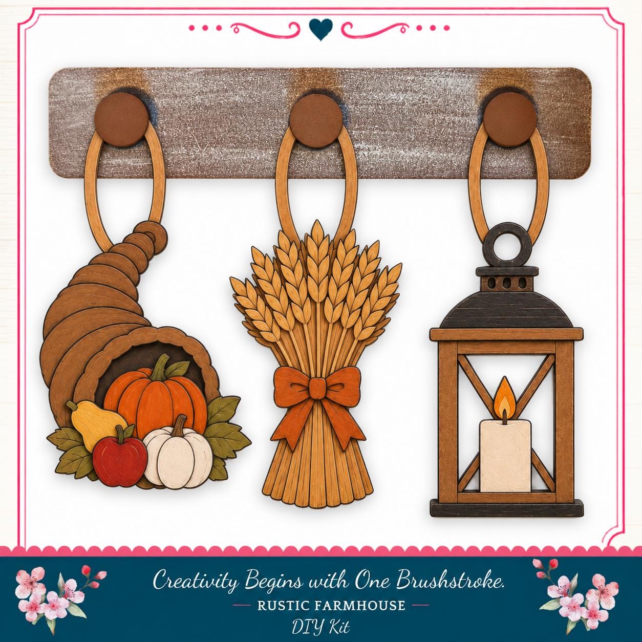 a rustic farmhouse-style DIY kit with three wooden ornaments hanging on a wooden board. The ornaments include a carved wooden cornucopia, a bundle of wheat, and a lantern with a lit candle.