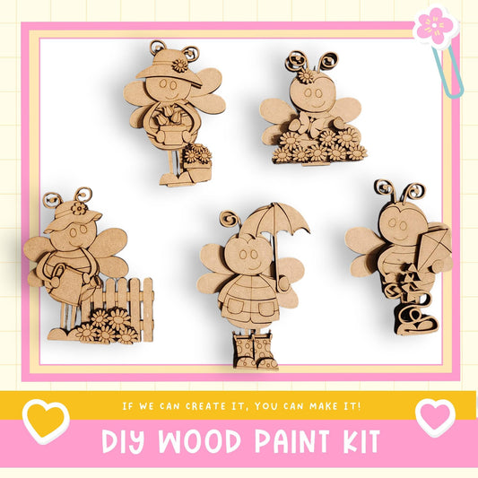 The image is a DIY wood paint kit featuring five wooden bee figurines in various poses, including one holding an umbrella.
