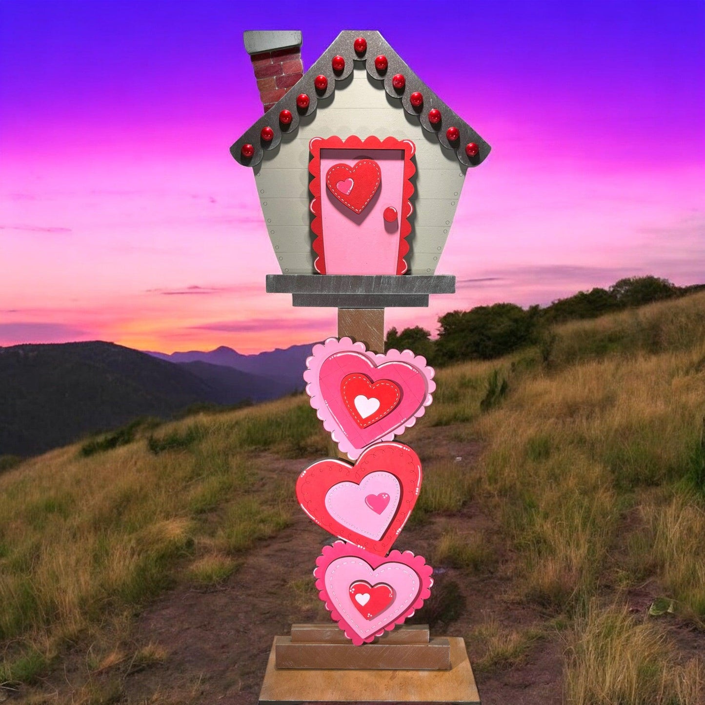 a house with hearts on a stand on a hill