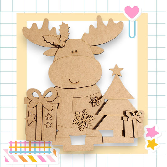 A cardboard cutout of a smiling moose holding a gift box and a Christmas tree, set against a grid background with a heart and stars.