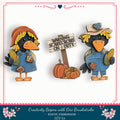 two wooden scarecrow dolls, each holding a piece of corn, standing next to a sign that warns of scarecrows on duty.