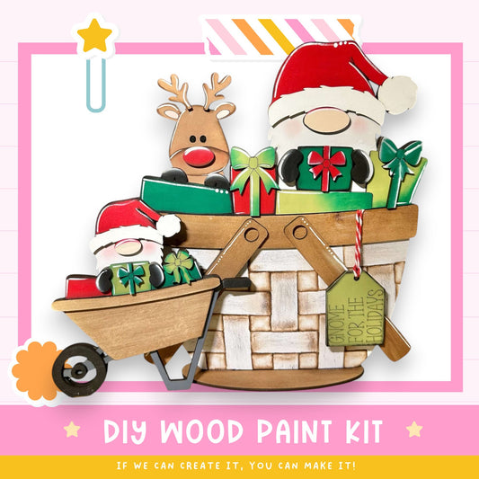 The image is a colorful and festive DIY wood paint kit featuring a wooden basket with a reindeer, Santa Claus, and other holiday-themed decorations. The kit appears to be made of wood and is designed for painting, with a label indicating it is a "DIY WOOD PAINT KIT" that can be created with the provided materials.