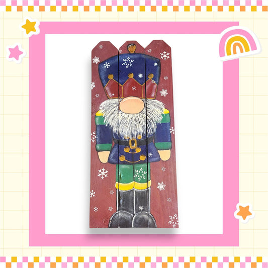A wooden nutcracker figure with a colorful outfit and a crown, surrounded by snowflakes, is depicted in the image.