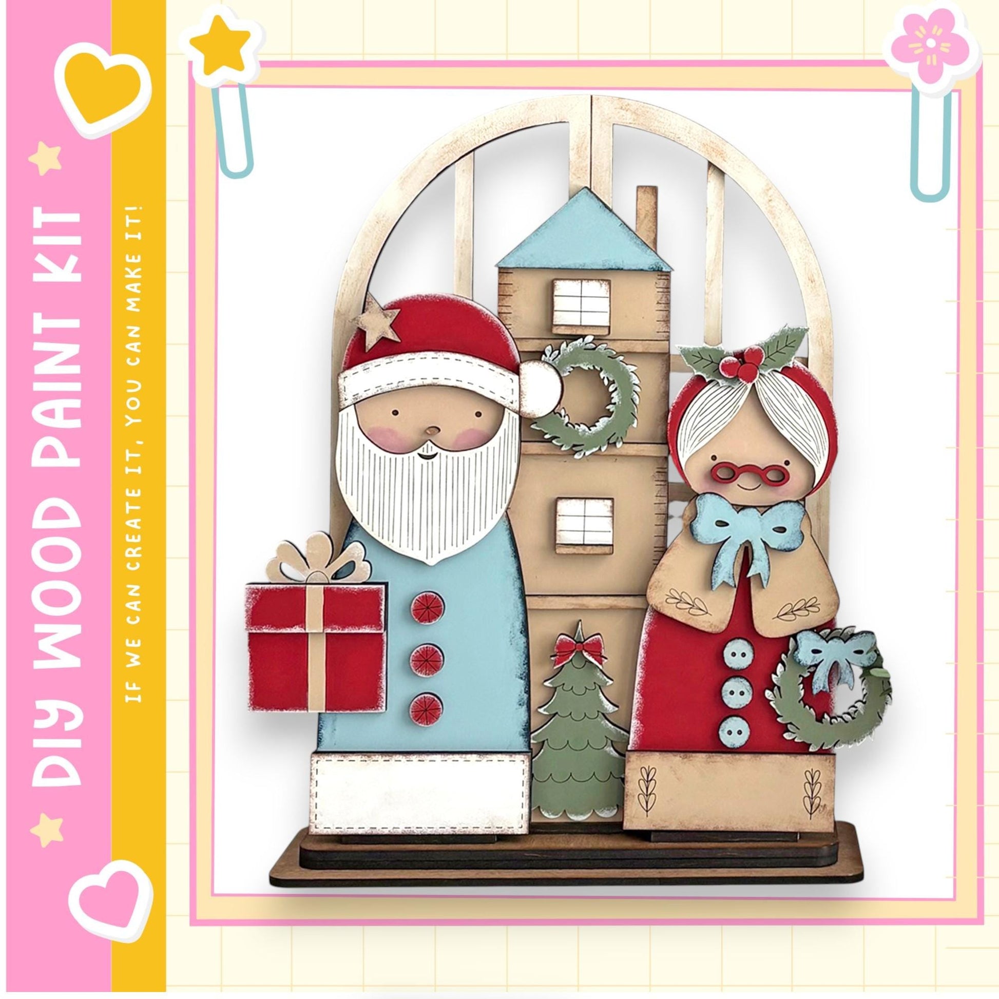 A wooden Christmas-themed display featuring a Santa Claus figure holding a gift box and a Christmas tree, with a wreath and other holiday decorations.