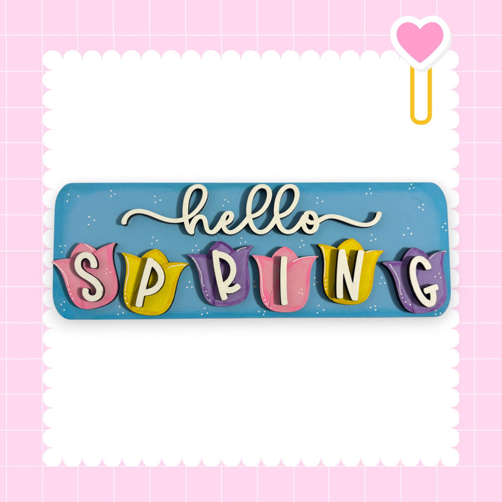 A colorful sign with the word "SPRING" written on it, surrounded by decorative elements such as hearts and flowers.