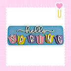 A colorful sign with the word "SPRING" written on it, surrounded by decorative elements such as hearts and flowers.