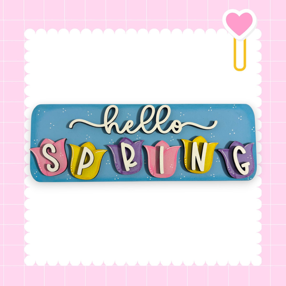 A colorful sign with the word "SPRING" written on it, surrounded by decorative elements such as hearts and flowers.