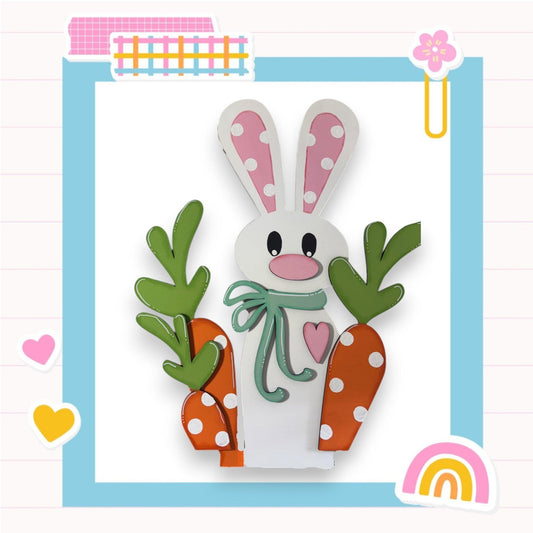 a paper cut of a bunny holding carrots