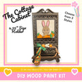 The image is a promotional poster for a DIY wood paint kit, featuring a wooden cabinet with a picture of a rabbit and carrots on it. The text on the poster includes the product name, a description of the product, and a call to action to create the product.