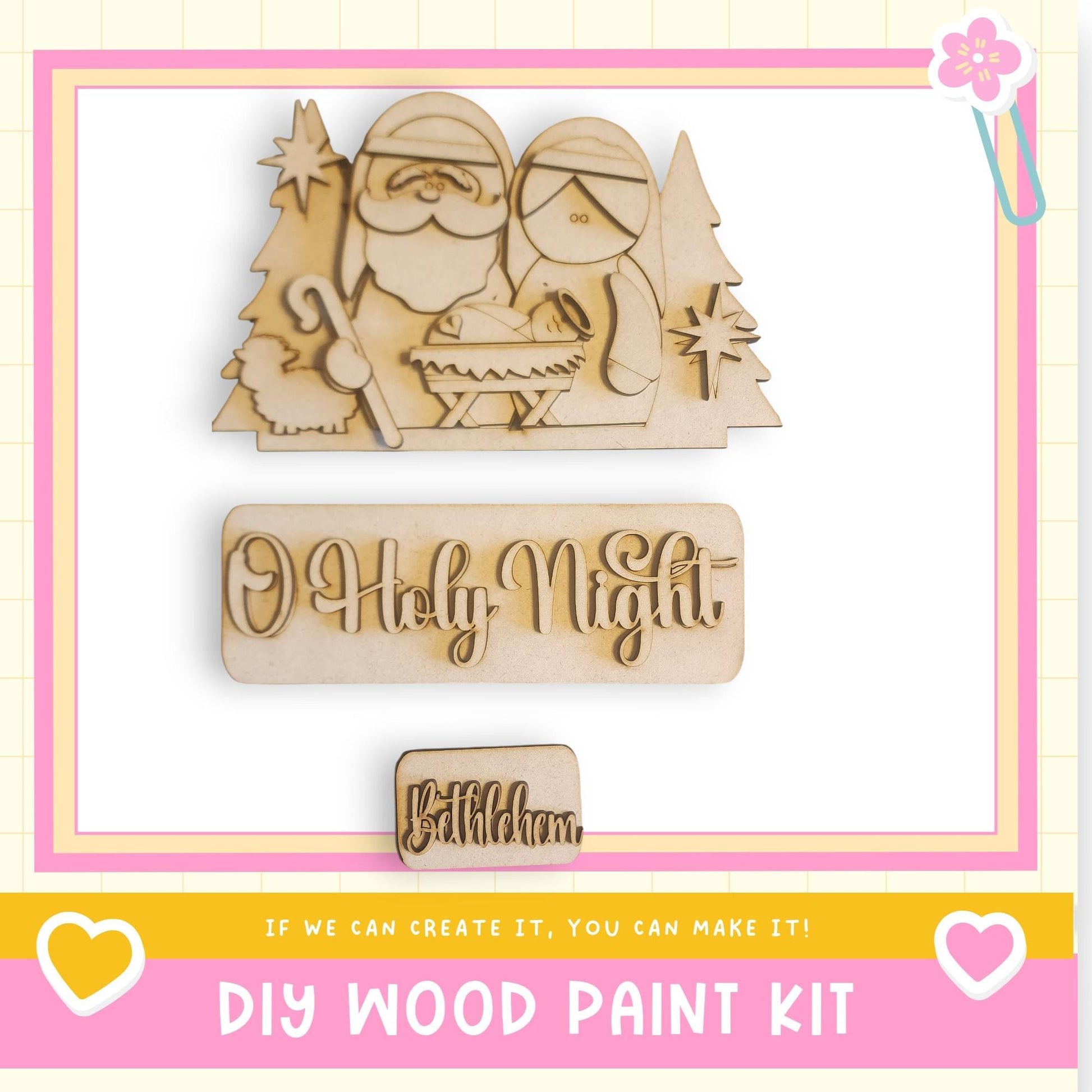 The image is a promotional image for a DIY wood paint kit, featuring a wooden nativity scene with Santa Claus, Mary, and baby Jesus. The kit is designed to allow users to create their own wooden nativity scenes.