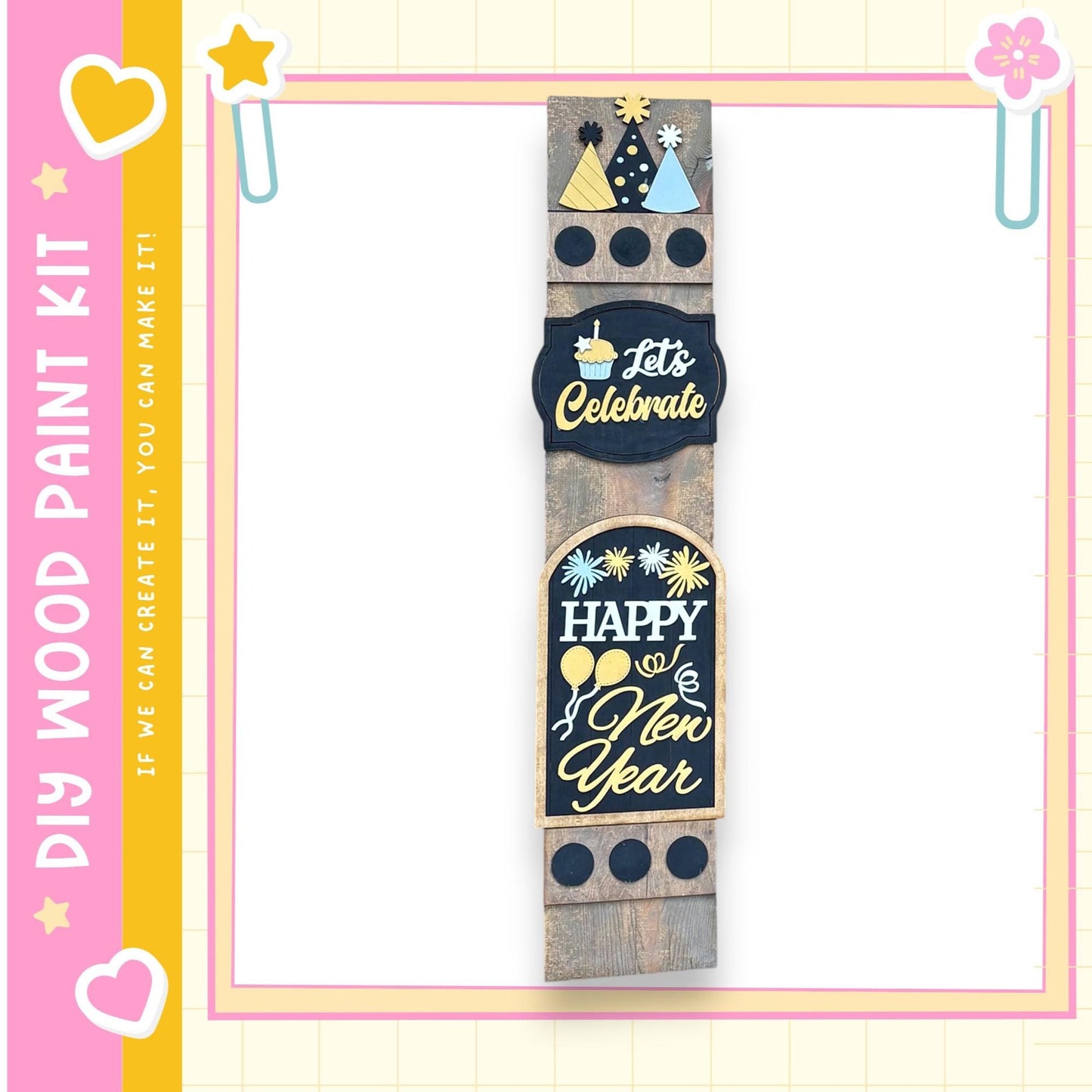 a wooden sign with various festive and celebratory messages, including "Let's Celebrate", "Happy New Year", and "If we can create it, we can make it!" The sign is displayed against a pink and yellow background with decorative elements such as hearts and stars.