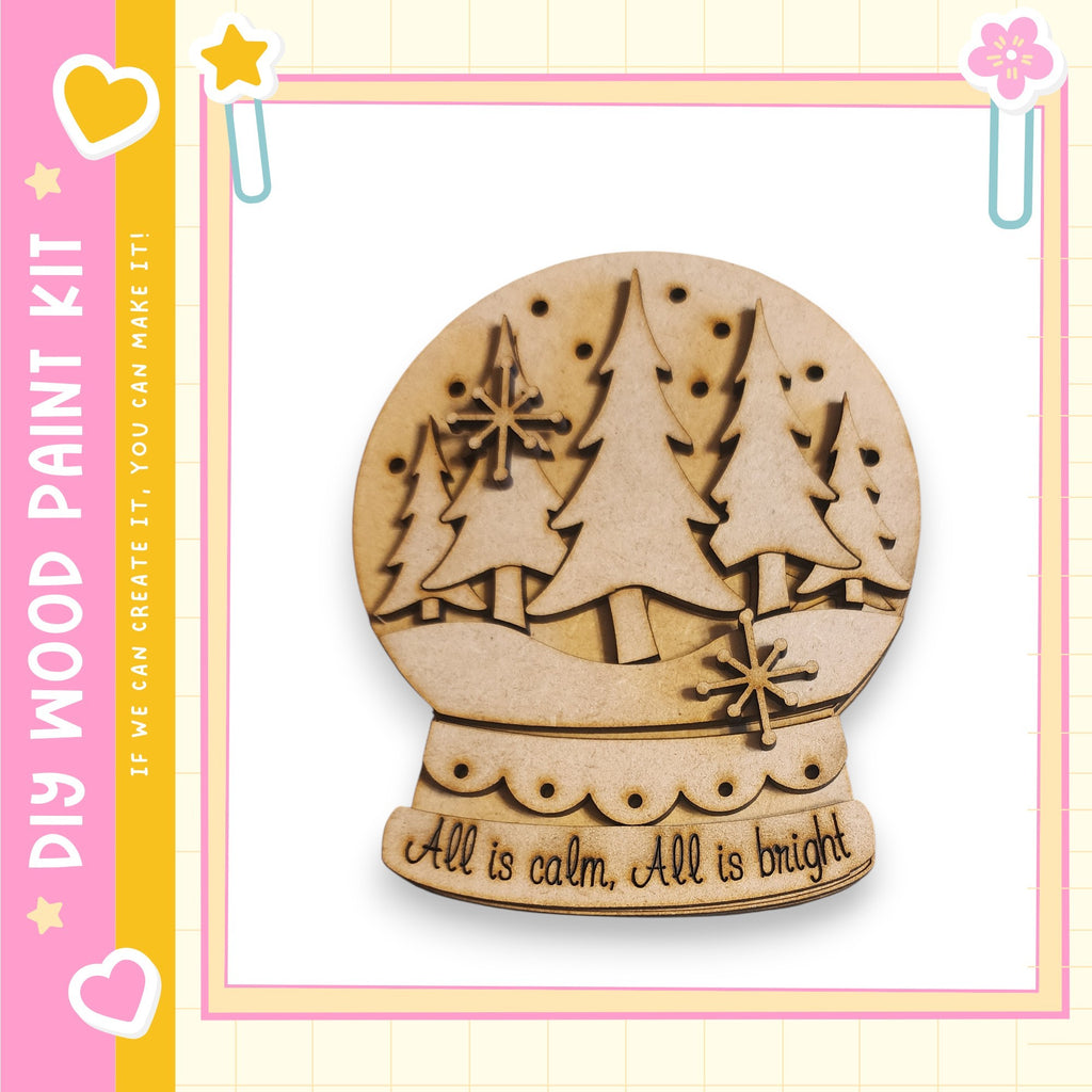 A wooden snow globe with a design of pine trees and snowflakes, accompanied by the text "All is calm. All is bright."