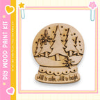 A wooden snow globe with a design of pine trees and snowflakes, accompanied by the text "All is calm. All is bright."