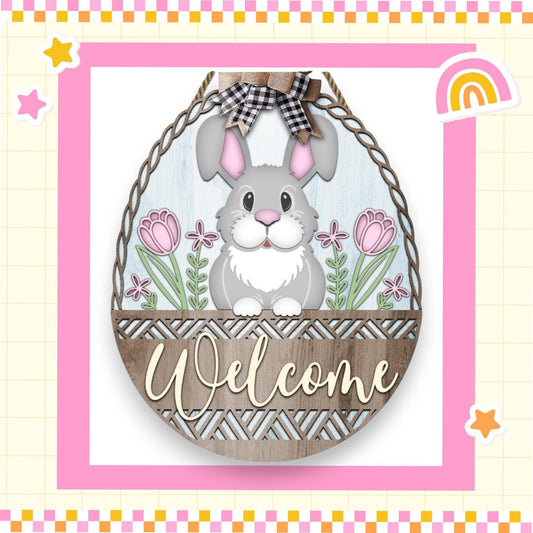 a welcome sign with a bunny in a basket