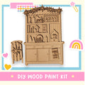 a DIY wood paint kit, including a wooden cabinet with various decorative elements such as snowflakes, hearts, and a rainbow.