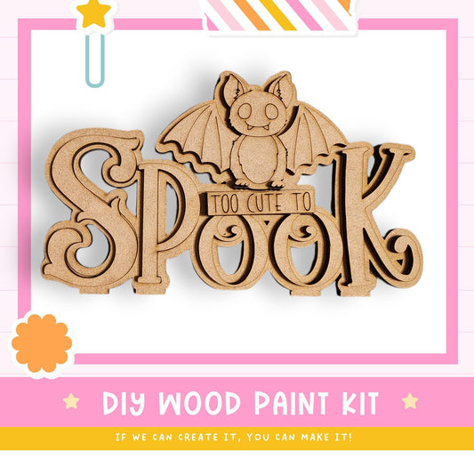 a DIY wood paint kit for creating a Halloween decoration, with a bat silhouette and the word "Spook" prominently displayed.
