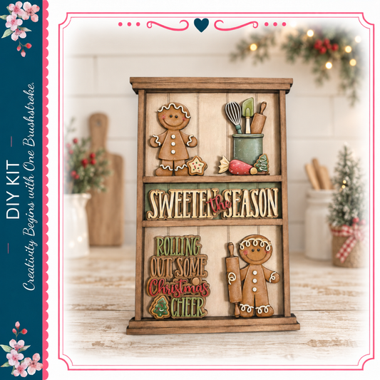 A wooden shelf with various holiday-themed decorations, including gingerbread men, a Christmas tree, and other festive items. The shelf has a sign that says "Sweeten the Season" and "Rolling Out Some Christmas Cheer".