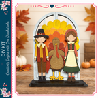 A DIY kit featuring a turkey, a boy in a red and yellow outfit, and a girl in a green dress, all posed in front of a wooden background with autumn leaves.