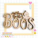 a wooden sign with the text "Just here for the Boos" in a playful, Halloween-themed font.