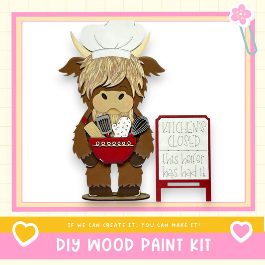 A wooden cutout of a chef holding a bowl and utensils, with a sign that reads "Kitchen's Closed" next to it.