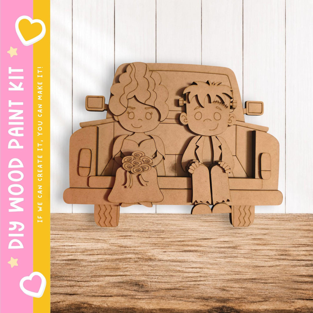 A wooden paint kit depicting a bride and groom sitting in the back of a truck.