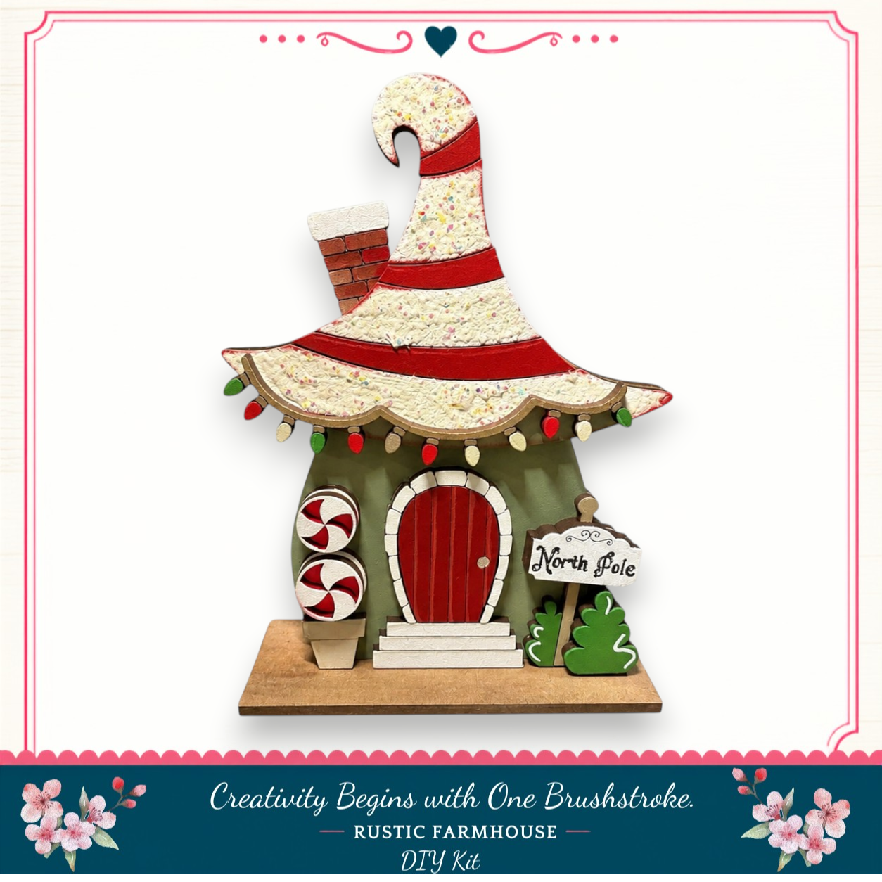 A whimsical, handcrafted Christmas ornament resembling a small house with a pointed roof, red door, and a sign that reads "North Pole". The ornament is decorated with candy canes and other festive elements, creating a charming holiday scene.