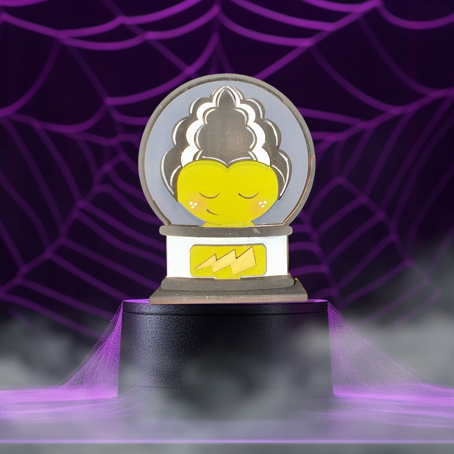 A whimsical, cartoonish illustration of a character with a yellow face and a black hairpiece, set against a purple background with a spider web pattern.