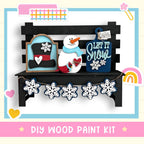 a snowman is sitting on a bench with a snowman decoration