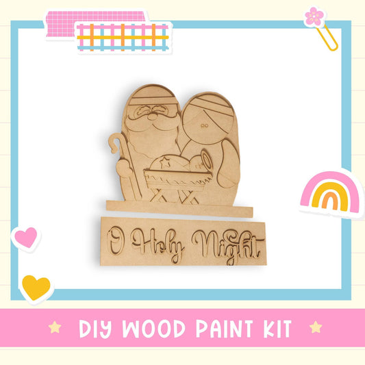 a DIY wood paint kit for creating a nativity scene, with a wooden figure of the baby Jesus and Santa Claus.