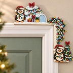 a festive holiday scene with two decorative penguin figures on a wall, one on the left and one on the right, both wearing Santa hats and surrounded by Christmas lights and presents.