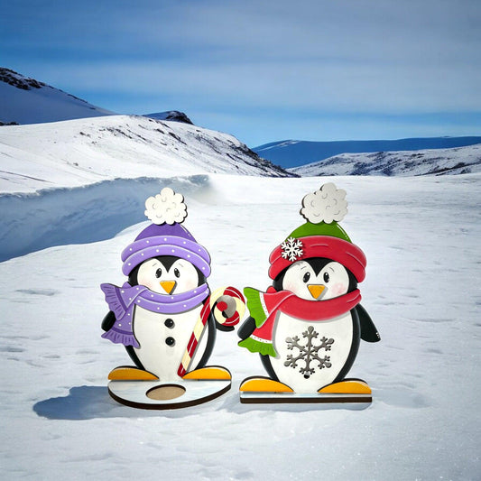 a couple of penguins that are standing in the snow