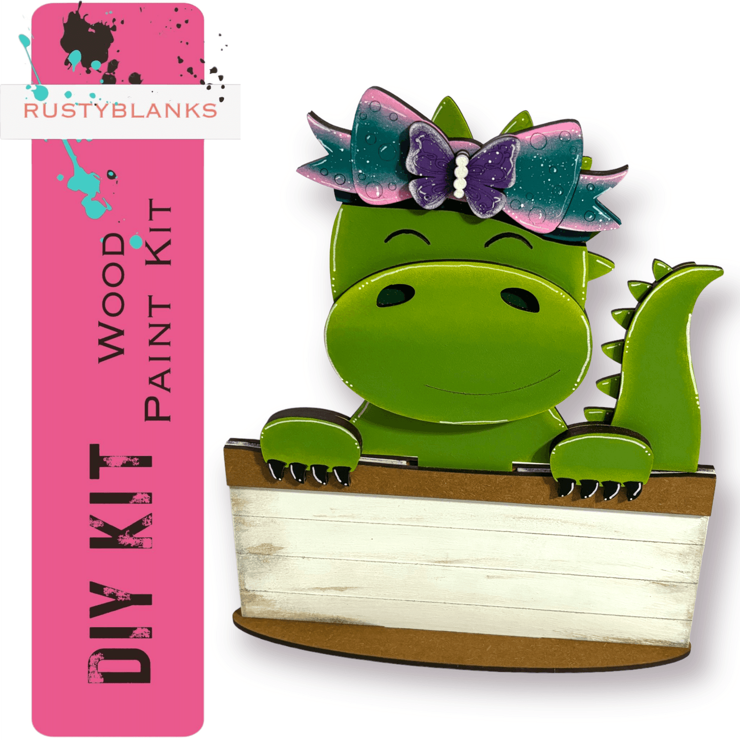 a green dinosaur with a bow sitting in a box